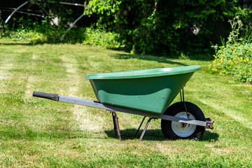 Green garden cart on a lawn in the sunshine