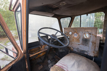 Cabin of abandoned radioactive vehicle, old rusty truck near ghost town Pripyat