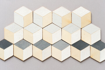 hand-painted (white and gray) trompe l'oeil (hexagonal) cubes on arranged on light gray paper background with space for text