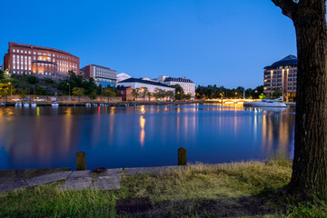 Night city skyline of an old European city with a bay of water. Citylights casting reflections on the water.