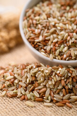 Organic Thai highland brown rice grain in a bowl and pouring (Cargo rice, Loonzain rice or Husked rice), Healthy food