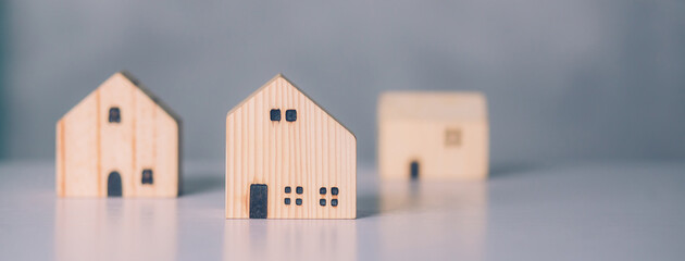 Naklejka premium Mini wooden home model concept, investment of real estate and asset, tax of property and rental for finance, no people, small house and inspiration, mortgage and loan for residence, business concept.