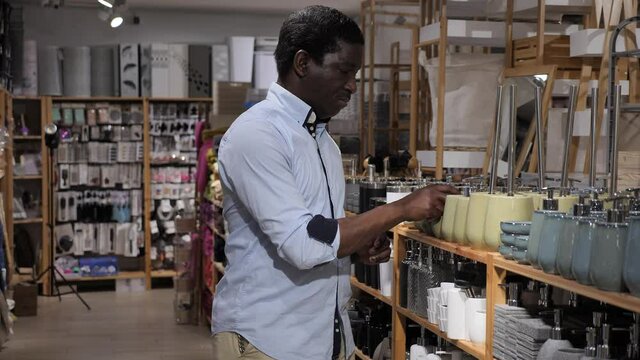 Portrait of African American shopper choosing bathroom accessories in home decor shop. Home improvement concept