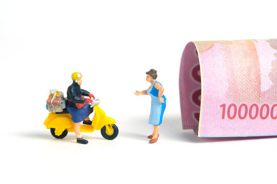 Miniature people toys conceptual photography. COD (Cash on delivery) service. Postman courier with cash money paper, isolated white background.