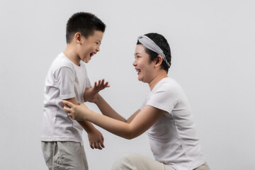 Young adult female cancer patient spending time with little son on gray background. Cancer and family support concept.