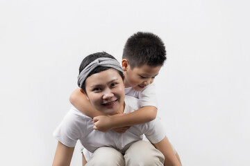 Young adult female cancer patient spending time with little son on gray background. Cancer and family support concept.