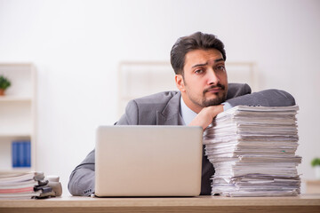 Young male employee unhappy with excessive work in the office