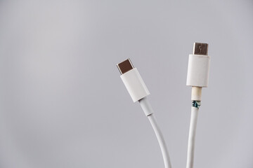 Close-up of a torn and intact type C mobile phone charging wire.