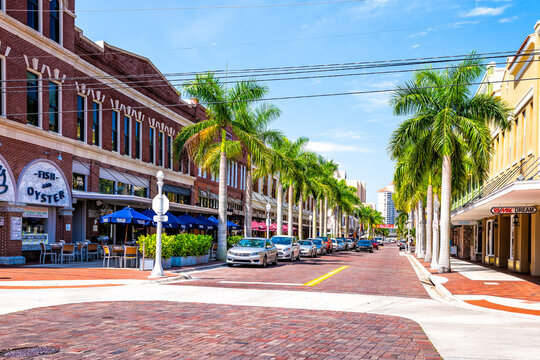 Fort Myers, USA - April 29, 2018: City town main street during sunny day in Florida gulf of mexico coast with shopping and restaurants row palm trees