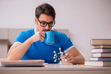 Young male student physicist studying molecular model