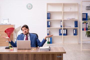 Fototapeta na wymiar Young male employee sitting at workplace