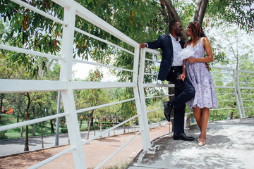 Pareja de novios africanos enamorados se dan besos y abrazos en un parque 