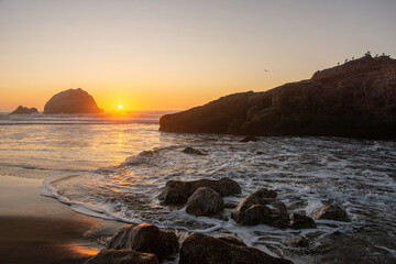 Sunset over Pacific Ocean rocky shoreline and beach