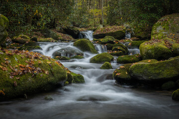 Low Angle of Water Rushing Around Mossy Boulders