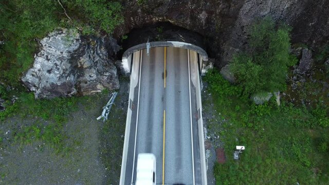 Looking down at traffic passing through tunnel entrance E16 highway between Bergen and Voss Norway - Dalekvam Beitlatunnel static aerial birdseye view