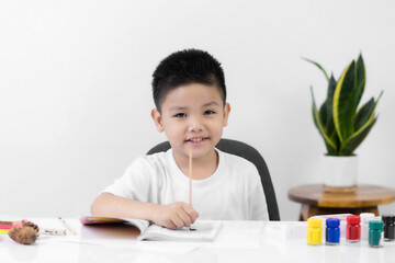 Happy little Asian kid at the table draw with watercolor Learning and education of kid.