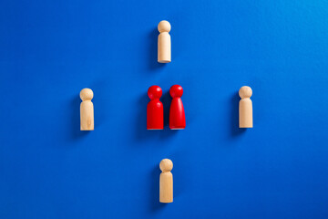 A wooden figure standing with a team to influence and empowerment.