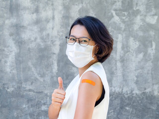 Vaccinations, bandage on vaccinated people's arm concept. Happy business Asian woman wearing white...