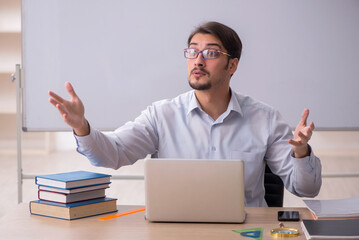 Young male teacher in front of whiteboard