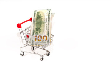 shopping cart with 100 dollars banknotes on white background