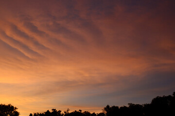 Pastel colors from orange to blue with soft cloud in an evening sky. Background