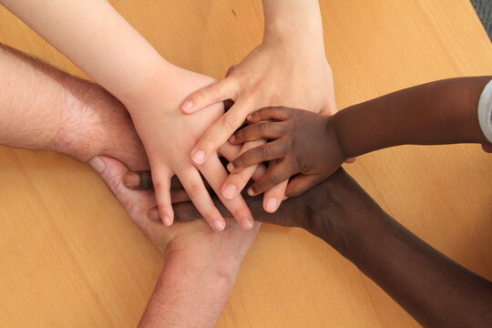 Hands young and adult layering and depicting racial harmony..