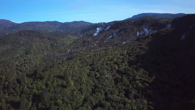 Aerial shot, of the streaming forest in Tokaanu, on a Sunny day in New Zealand, steam everywhere from the ground, wide angle