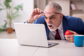 Old male employee working from home during pandemic