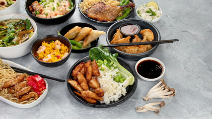 Assorted asian dishes and snacks on dark gray background. Traditional food concept.