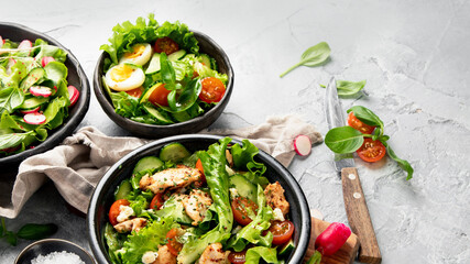 Freshly made salads on light gray background. Seasonal food concept.