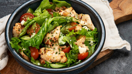 Fresh chicken salad on drak gray background. Healthy food concept.