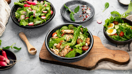 Freshly made salads on light gray background. Seasonal food concept.
