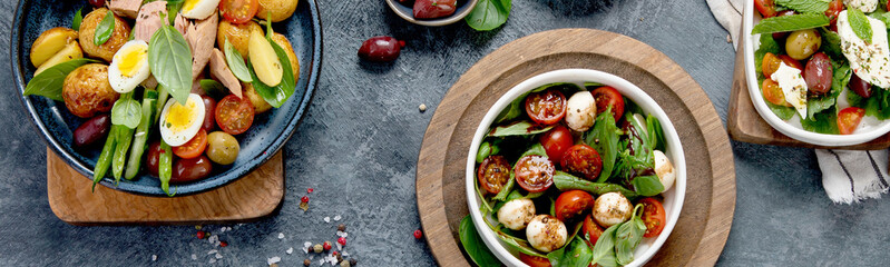 Assorted salads on dark gray background. Seasonal food concept.