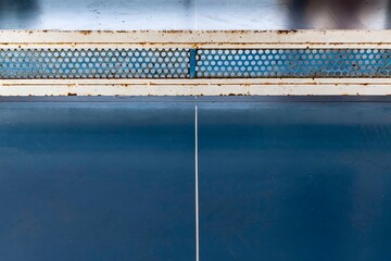 Close - up of empty blue wooden table tennis or ping-pong table without players