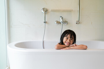 happy asian girl taking a bath together on a bathtub
