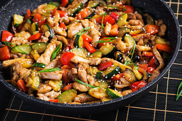 Stir fry with chicken, zucchini and sweet peppers - Chinese food.