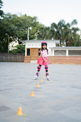 smiling 5 year old asian girl going on her in-line skates