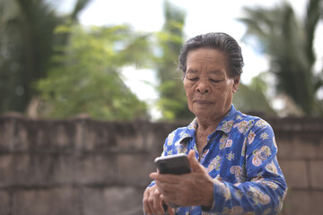 Fototapeta premium Asian Senior woman holding a smartphone.