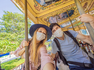 Man and woman wearing a medical mask during COVID-19 coronavirus at an amusement park