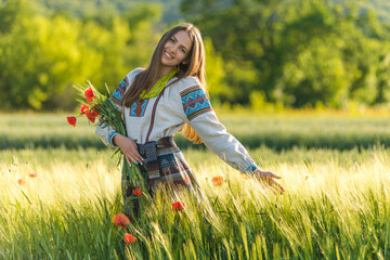 Beautiful smiling slavonic girl in national embroidered costume on barley field