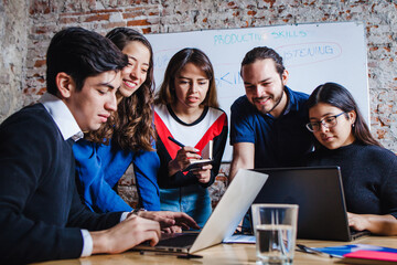 Group of young latin business people working with computer while spending time in the office in...