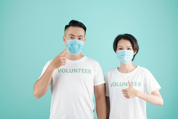 Young couple in medical mask inviting other people to work as volunteers and help people during coronavirus pandemic