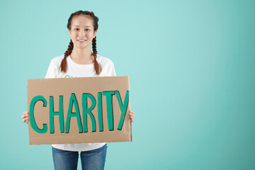 Lovely smiling young woman holding big charity placard to attract more people