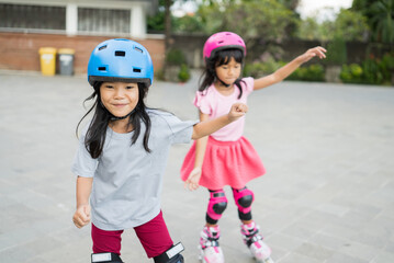 two asian girl going on her in-line skates in the park