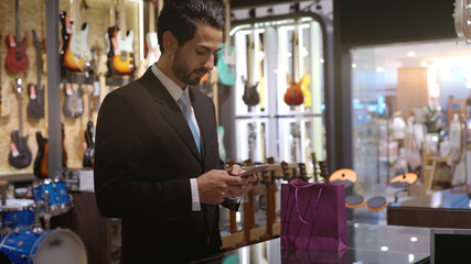 An upwardly mobile Muslim man using smart payment to pay for a product at a sale terminal with nfc identification payment for verification and authentication