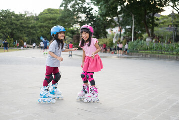 two asian girl going on her in-line skates in the park