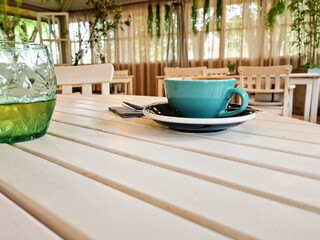 A blue cup of coffee in a restaurant. Eating outside home in a cafeteria.