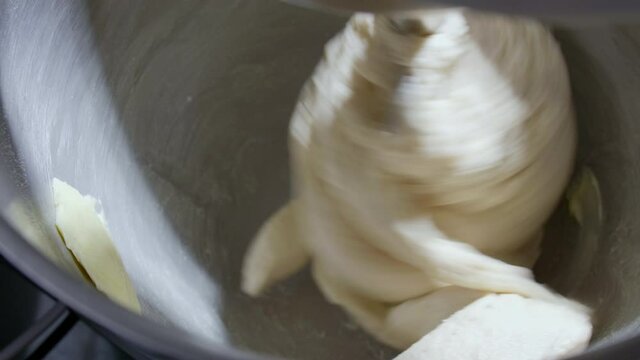 4K Close up bread dough making process by using flour mixing machine. Machine knead bread dough. Homemade bread raw mix with small machine. Food concept.