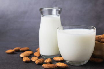 Milk with almonds nut on dark background copy space organic healthy concept.