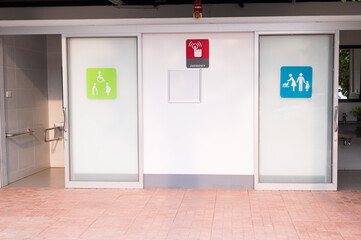 Outdoor public toilet and different signs.The pregnant symbol and disable symbol on toilet doors.